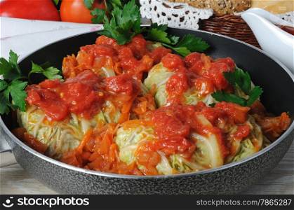 stuffed savoy cabbage in a pan under the onion and carrot gravy
