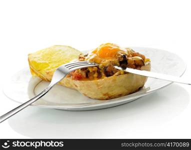 stuffed squash with cheese on a plate with fork and knife