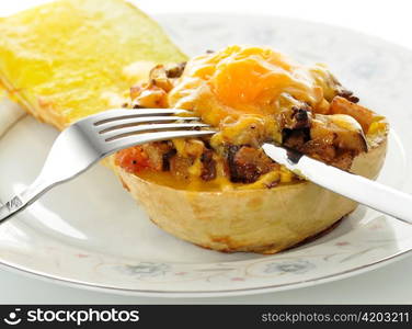 stuffed squash with cheese on a plate with fork and knife