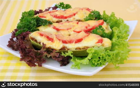 Stuffed zucchini with a mixture of vegetables with tomato and cheese with herbs