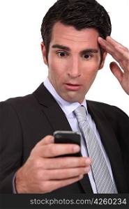 Stunned businessman reading a text message