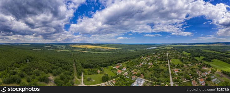 Stunning aerial panorama from a drone of countryside, village, green fields and trees, agriculture concept.