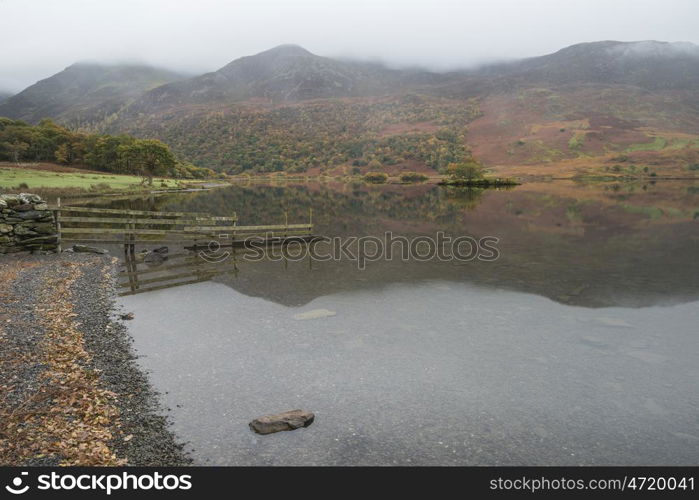 Stunning Autumn Fall landscape image of Crummock Water at sunrise in Lake District England