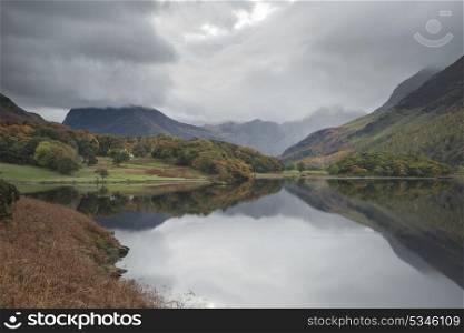 Stunning Autumn Fall landscape image of Crummock Water at sunrise in Lake District England