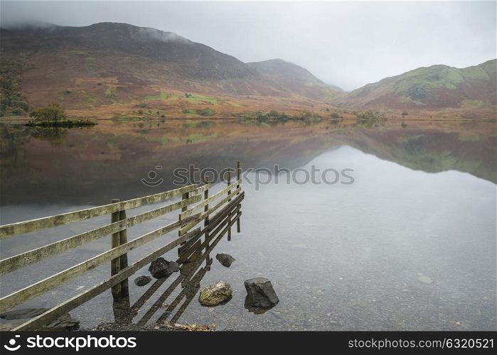 Stunning Autumn Fall landscape image of Crummock Water at sunrise in Lake District England