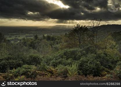Stunning Autumn Fall sunset over forest landscape with moody dramatic sky