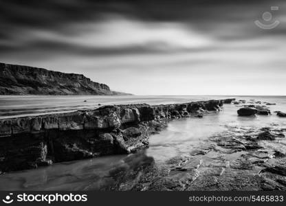 Stunning black and white seascape coastline and rocky shore at sunset