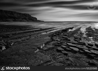 Stunning black and white seascape coastline and rocky shore at sunset