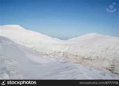 Stunning blue sky mountain landscape in Winter with snow covered slopes