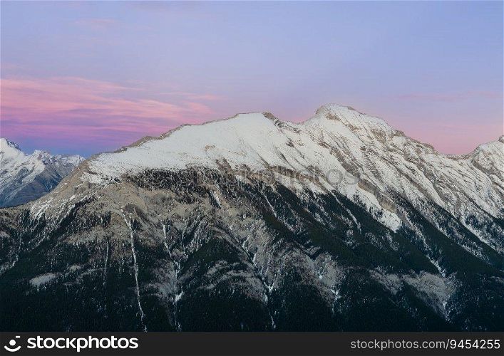 Stunning Canadian Rocky mountains twilight scene of snow capped mountain at Banff National Park in Alberta, Canada. View from Banff Gondola Sulphur Moutain.