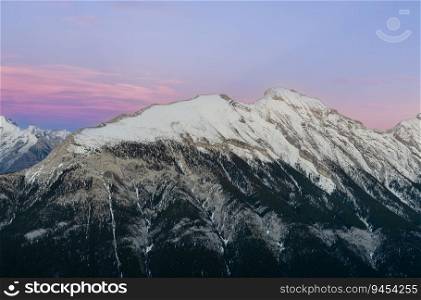 Stunning Canadian Rocky mountains twilight scene of snow capped mountain at Banff National Park in Alberta, Canada. View from Banff Gondola Sulphur Moutain.