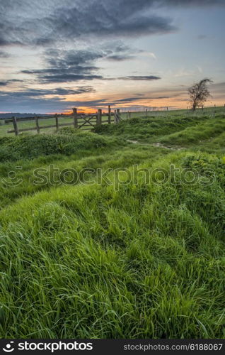 Stunning English countryside landscape over fields at sunset