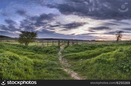 Stunning English countryside panorama landscape over fields at sunset