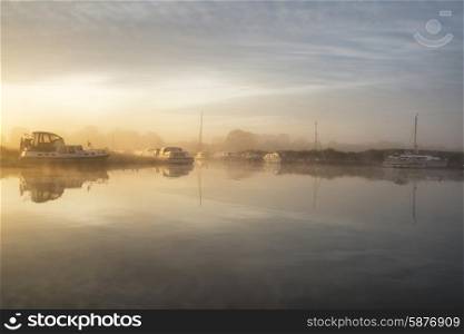 Stunning foggy sunrise over peaceful river landscape in English countryside