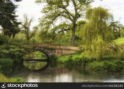 Stunning landscape image of old medieval bridge over river with mirror like reflections