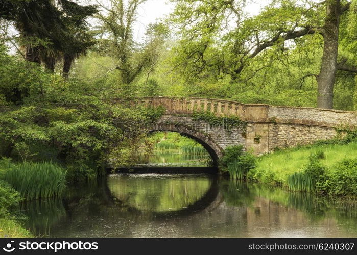 Stunning landscape image of old medieval bridge over river with mirror like reflections