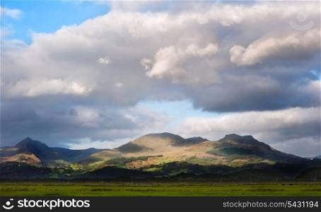 Stunning landscape image panorama view of Snowdon and mountain ranges in National Paark in Wales at sunset