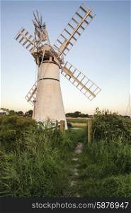 Stunning landscape of windmill and river at sunrise on Summer morning