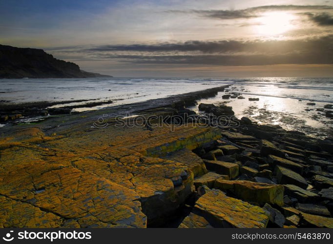 Stunning landscape seascape coastline and rocky shore at sunset