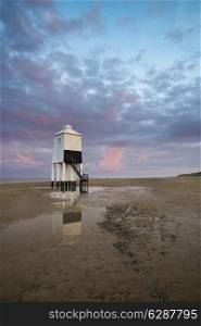 Stunning landscape sunrise stilt lighthouse on beach