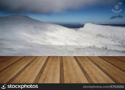 Stunning landscape views from top of deep snow covered mountains in Winter with wooden planks floor