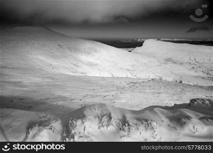 Stunning landscapeof snow covered mountains in Winter in black and white