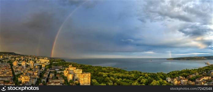 Stunning panorama of a big rainbow over the sea and coast after the rain