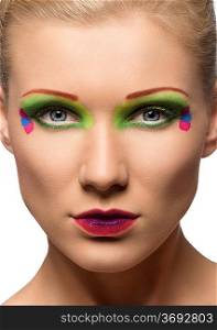 stunning portrait of a young and cute woman with dreative and colorful make up looking camera