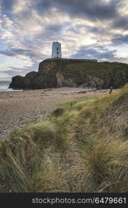 Stunning Summer landscape image of lighthouse on end of headland. Beautiful Summer landscape image of lighthouse on end of headland with beautiful sky