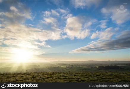 Stunning sunrise over countryside landscape with beautiful Autumn sky