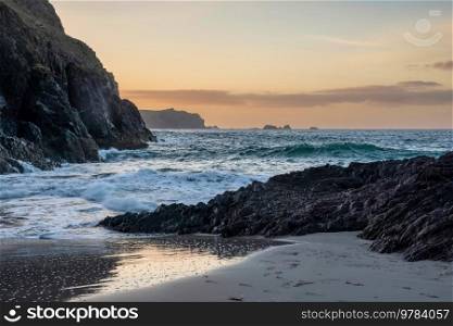 Stunning sunrise over Kynance Cove landscape in Cornwall England with vibrant sky and beautiful turquoise ocean