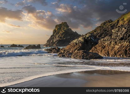 Stunning sunrise over Kynance Cove landscape in Corwnall England with vibrant sky and beautiful turquoise ocean