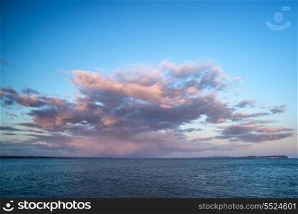 Stunning sunset cloud formation over calm sea landscape