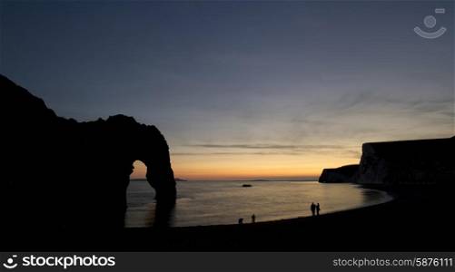 Stunning sunset silhouette landscape image of Durdle Door in England