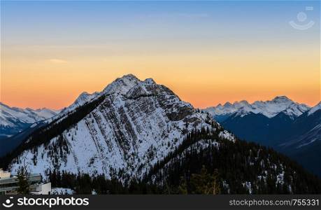 Stunning sunset skyline of snow capped Canadian Rocky mountains at Banff National Park in Alberta, Canada. View from Banff Gondola Sulphur Moutain.