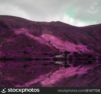 Stunning surreal color mountain landscape reflected in lake