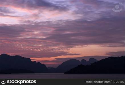 Stunning twilight view of Limestone mountains and lake in Khao Sok National Park, Surat Thani Province, Thailand. Long exposure shot.