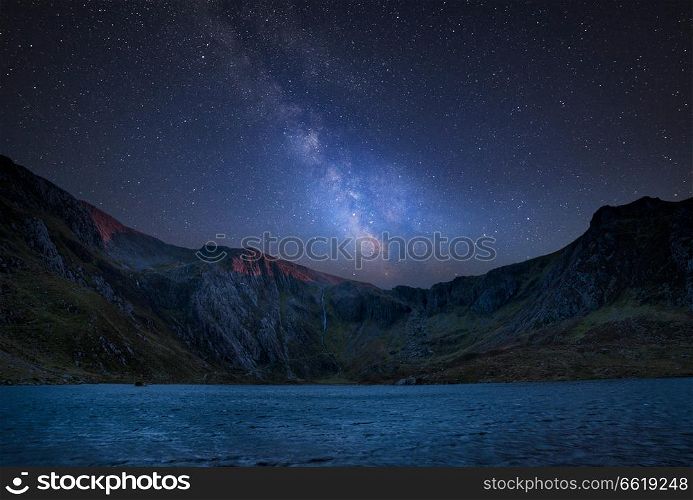 Stunning vibrant Milky Way composite image over Beautiful landscape image of Llyn Idwal and Devil&rsquo;s Kitchen in Snowdoina