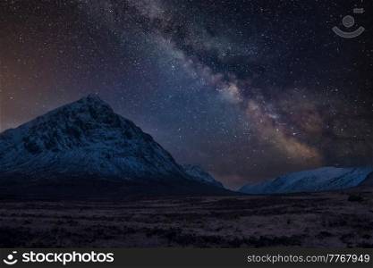 Stunning vibrant Milky Way composite image over landscape of snowcapped Winter mountains in Scotland