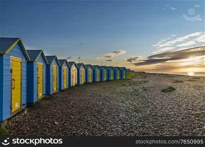 Stunning vibrant sunrise landscape of beach huts on English South coast