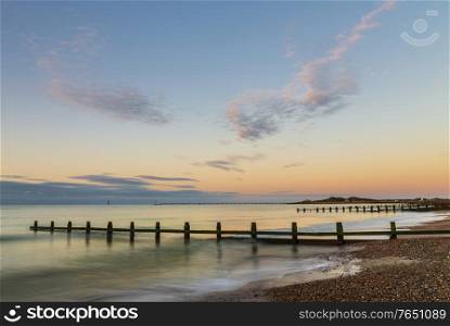 Stunning vibrant sunrise over beach landscape on English South coast