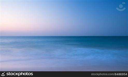 Stunning vibrantl sunrise landscape image of calm sea looking ou. Beautiful colorful sunrise landscape image of calm sea looking out from Porthcurno beach on South Cornwall coast in England