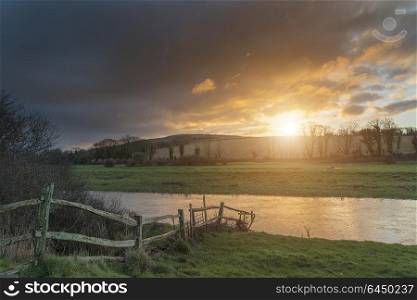 Stunning Winter sunrise landscape of Cuckmere River winding through South Downs countryside in England