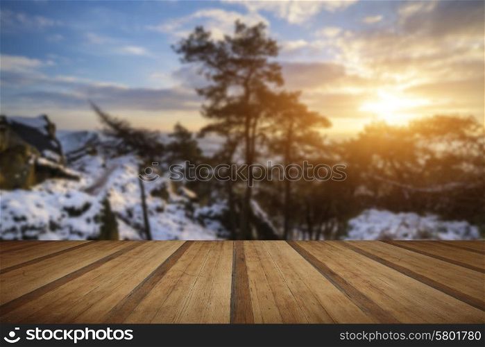 Stunning Winter sunset landscape from mountains looking over countryside with wooden planks floor