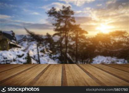 Stunning Winter sunset landscape from mountains looking over countryside with wooden planks floor
