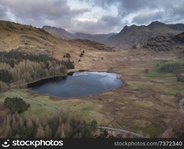 Stunnnig drone aerial sunrise landscape image of Blea Tarn and Langdales Range in UK Lake District