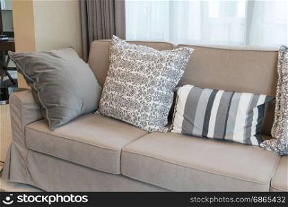 Sturdy brown tweed sofa with grey patterned pillows