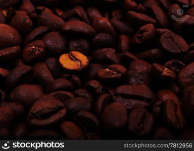 Style coffee beans background with one gold bean in the center. Great start of the day.
