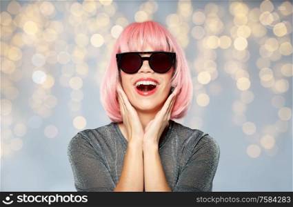 style, fashion and people concept - happy young woman in pink wig and black sunglasses over festive lights background. happy woman in pink wig and black sunglasses