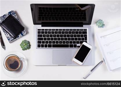 Styled white workspace with laptop, phone and coffee, flat lay top view scene. Styled workspace with laptop